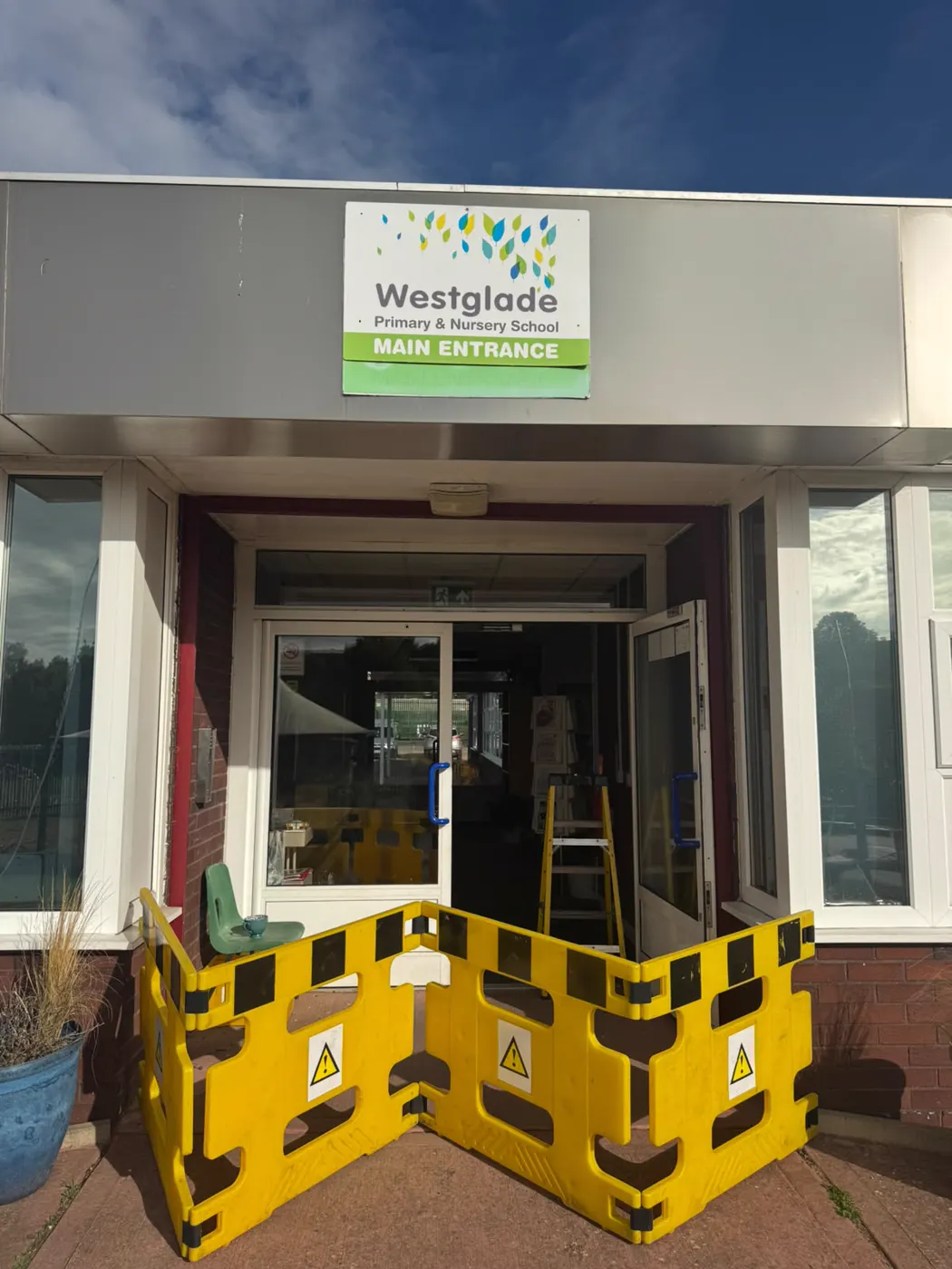 Main entrance of Westglade Primary and Nursery School Nottingham cordoned off with yellow barriers while the aluminium door transom closers are replaced