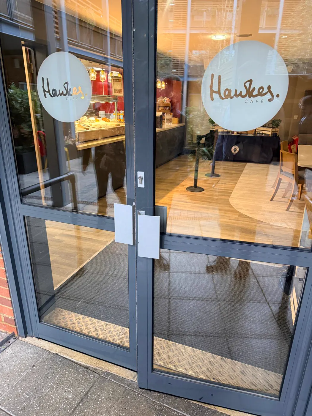 Double anthracite aluminium entrance doors to Hawkes Café at Kingston Grammar School, Kingston upon Thames, before transom closer and shoot bolt replacement