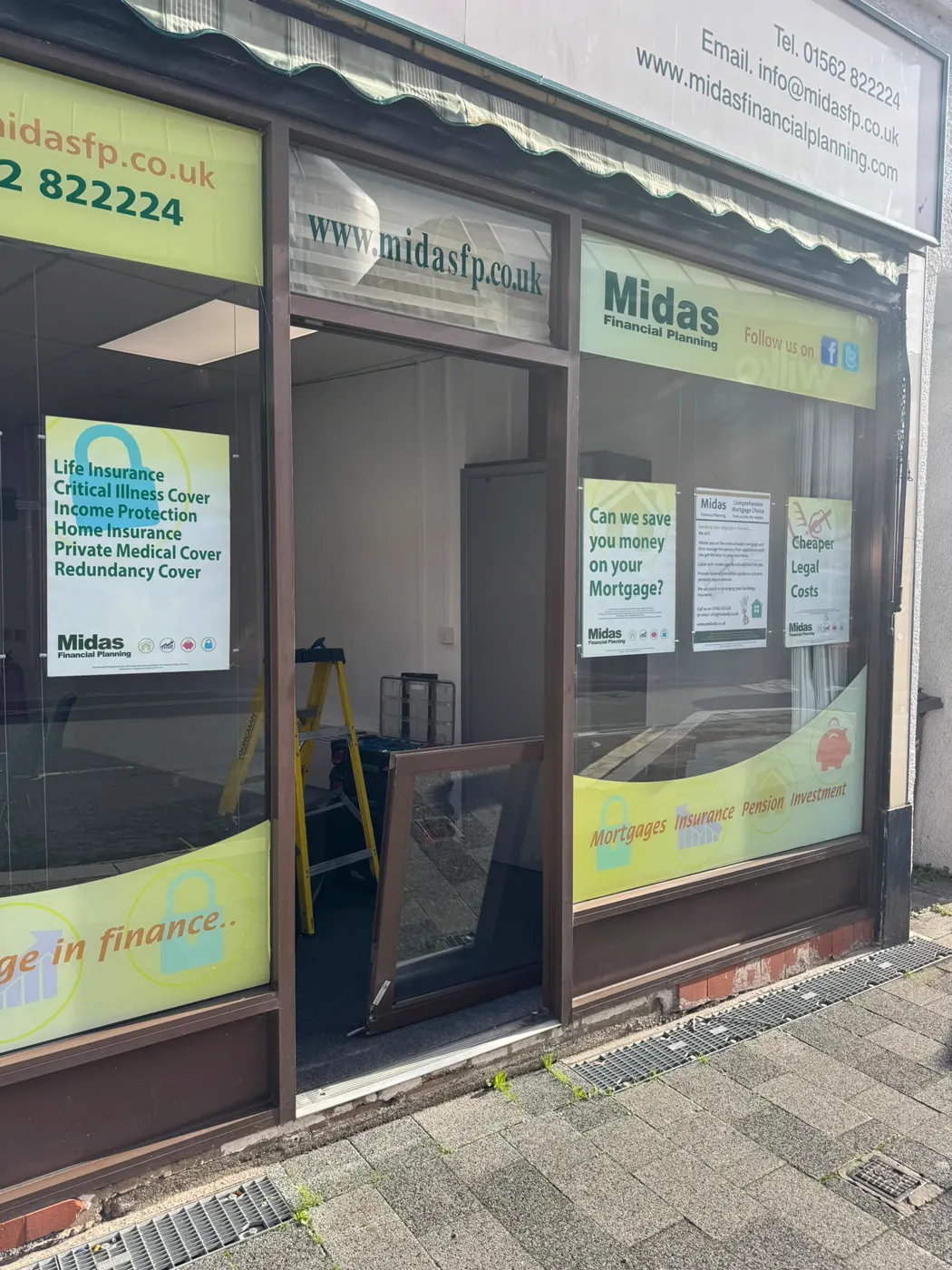 Midas Financial Planning shopfront in Kidderminster with the bronze aluminium entrance door lifted off and leaning inside beside a stepladder