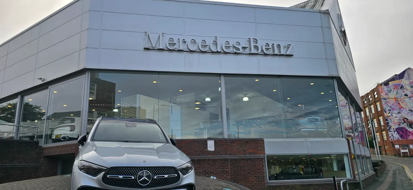 Mercedes-Benz showroom in Leicester with its full-height glazed frontage and a silver GLC parked on the forecourt